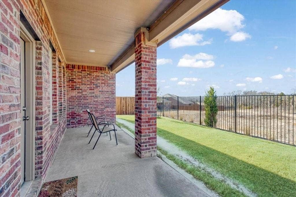 Covered concrete patio with brick columns