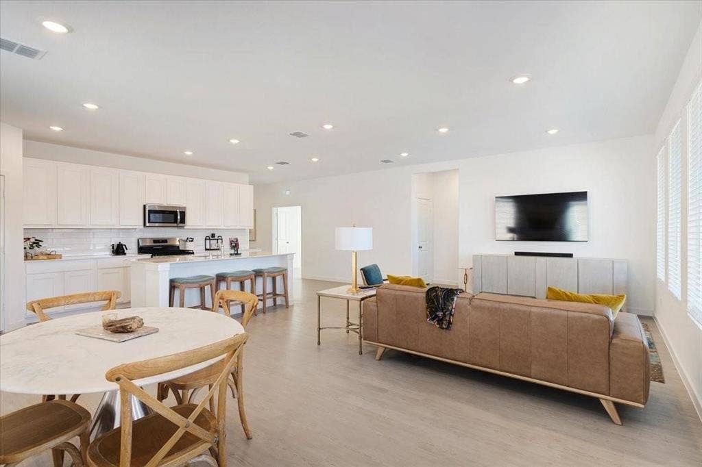 Open-concept living space featuring wood-finish flooring, recessed lighting, and ample natural light