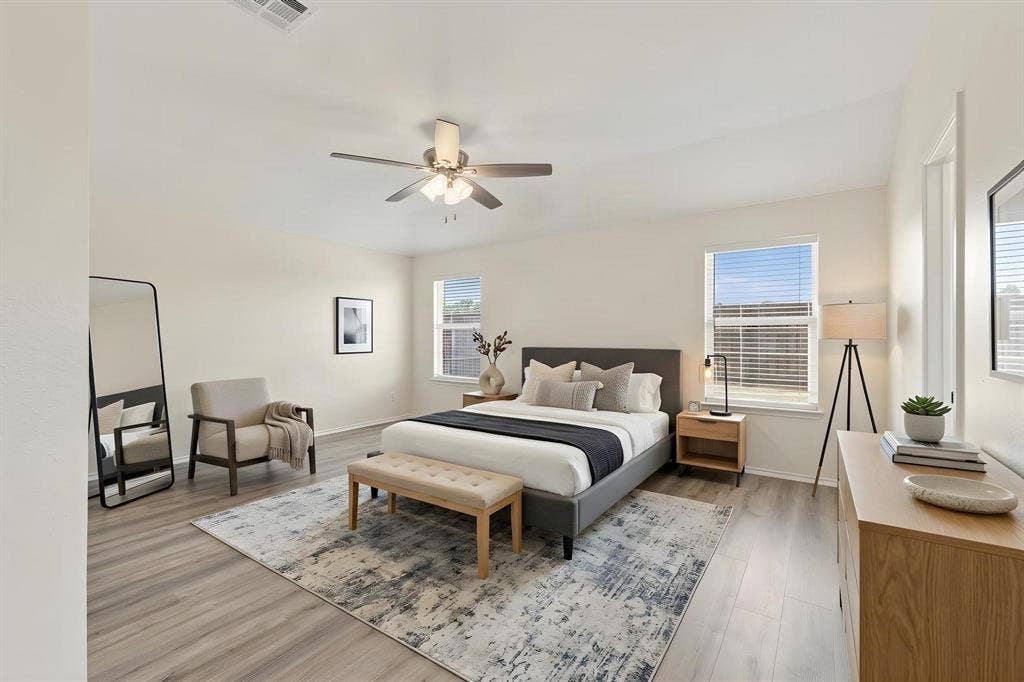 This room has been virtually staged using AI to illustrate its potential lighting, wood-finish flooring, ceiling fan, and multiple windows with blinds