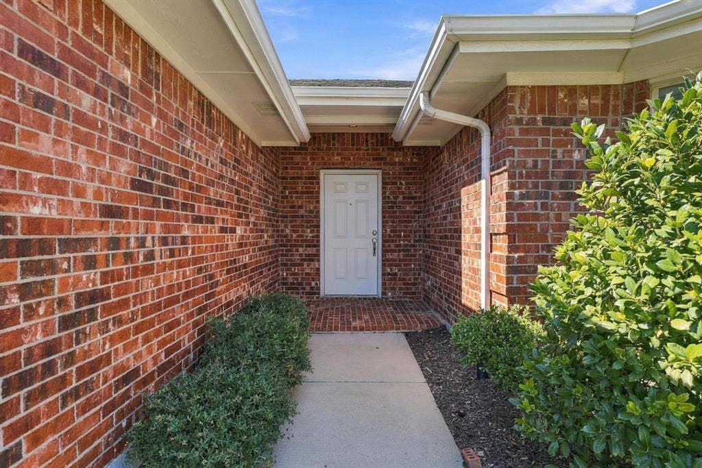Brick exterior with white gutters and downspouts