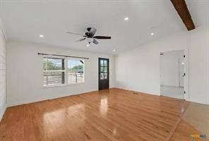 Hardwood flooring, recessed lighting, ceiling fan, exposed wood beam, and a paneled glass door