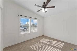Vaulted ceiling featuring a ceiling fan with integrated lighting, wall-to-wall carpeting, and a double window with blinds