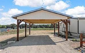 Freestanding carport with a metal roof and exposed wood beams