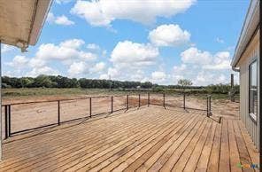 Expansive wood-plank deck with a black metal railing, offering extended outdoor living space