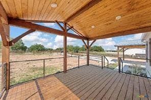 Covered porch featuring wood-finish decking, exposed wood beams, and recessed lighting