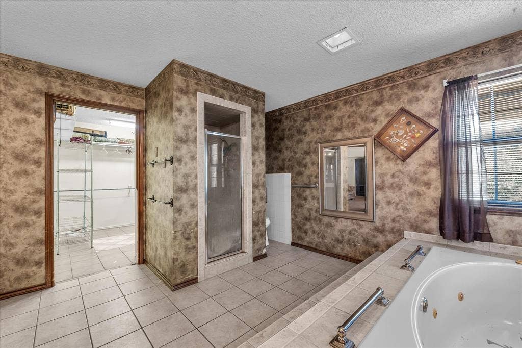 4201 N 19th Street, Waco, TX 76708 Tile flooring, glass-enclosed shower, built-in bathtub, window with blinds, and recessed lighting