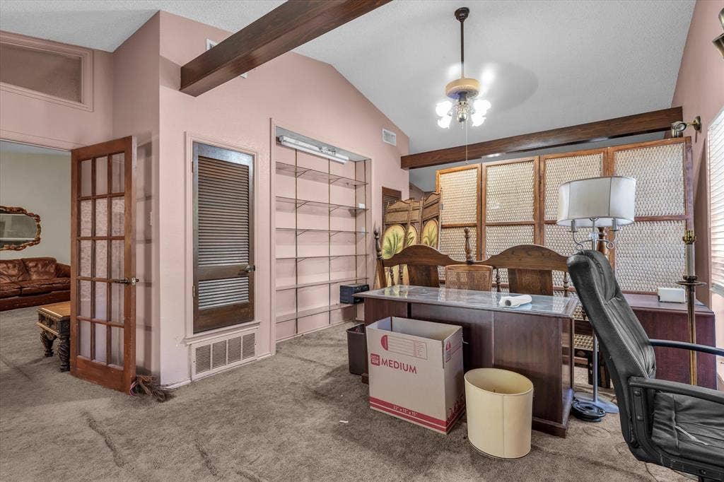 4201 N 19th Street, Waco, TX 76708 Vaulted ceiling with exposed wood beams, built-in shelving, wood-finish louvered door, and a glass-paneled entry door