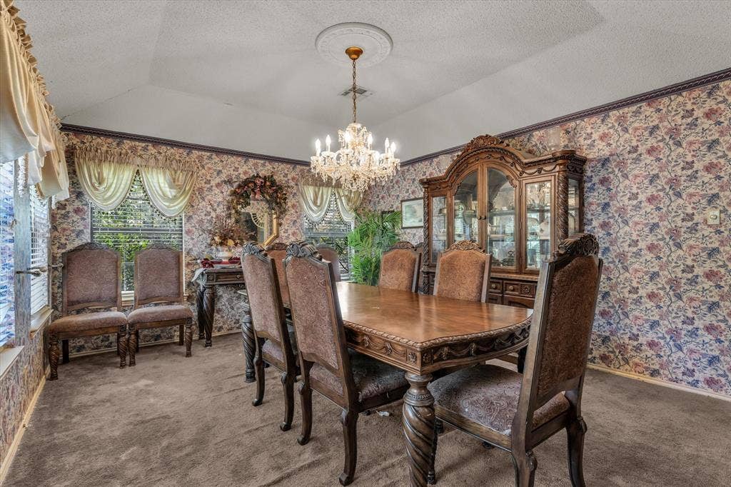 4201 N 19th Street, Waco, TX 76708 Vaulted ceiling with a central chandelier, patterned wallpaper, and carpeted flooring