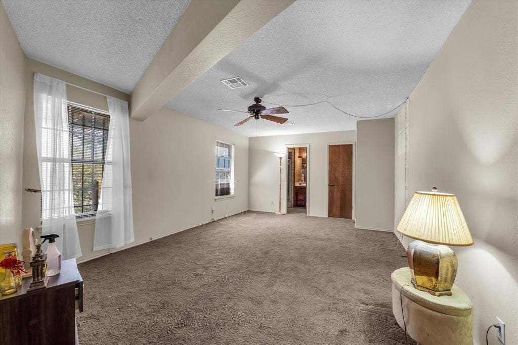4201 N 19th Street, Waco, TX 76708 Neutral wall finishes, textured ceiling, brown carpet flooring, and a ceiling fan with light