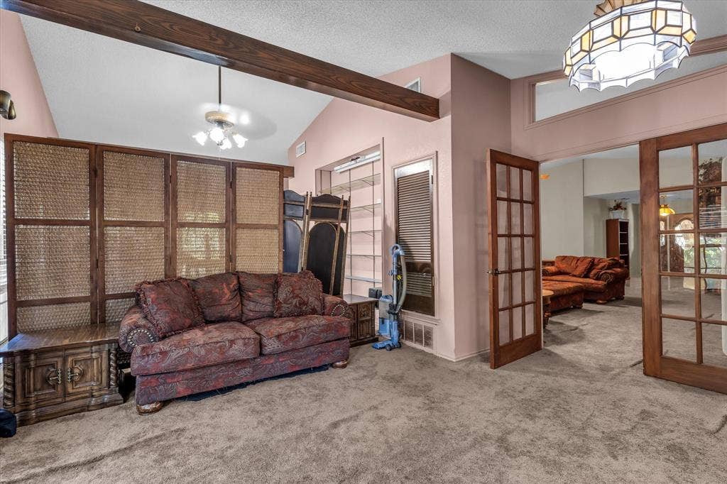 4201 N 19th Street, Waco, TX 76708 Vaulted ceiling with exposed wood beams, French doors with glass panels, and an overhead decorative light fixture