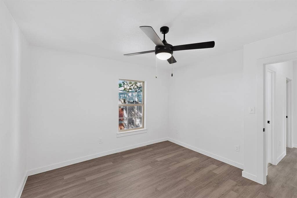 651 Ezekial Avenue, Dallas, TX 75217 Wood-finish flooring, white walls, and a window with white trim