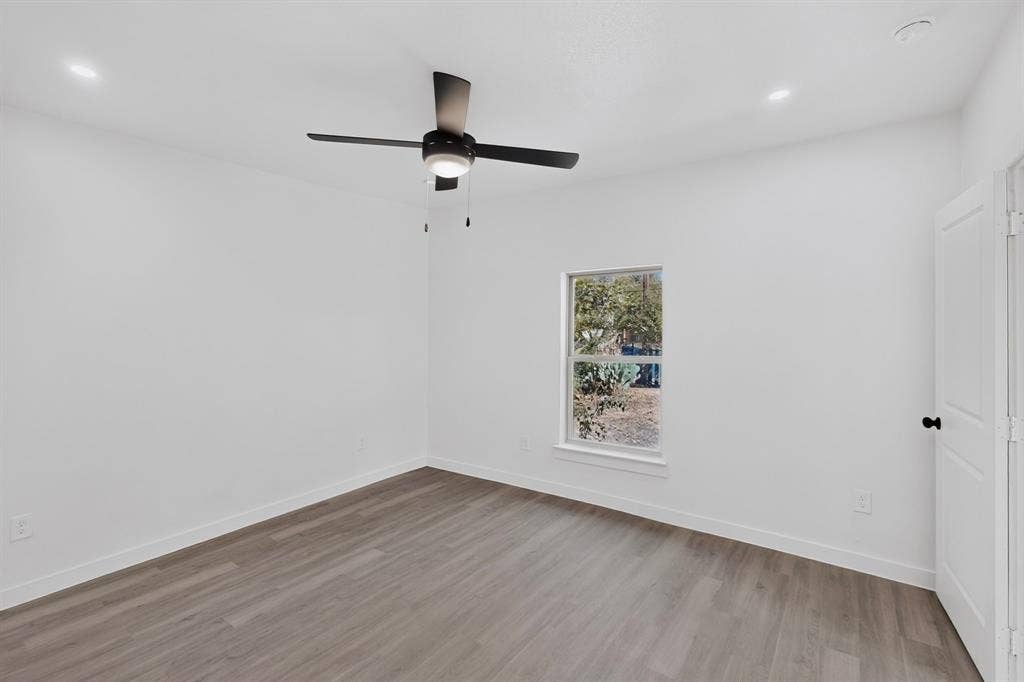 651 Ezekial Avenue, Dallas, TX 75217 Wood-finish flooring, white walls, and a window with a white frame
