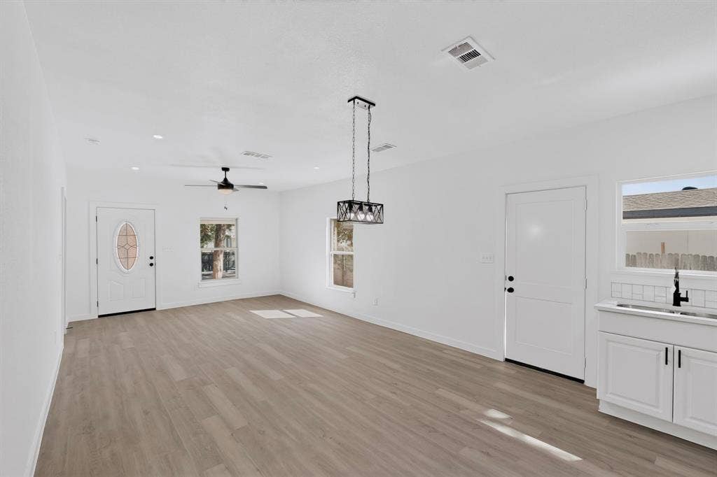651 Ezekial Avenue, Dallas, TX 75217 Open-concept living space featuring wood-finish flooring, recessed lighting, and a contemporary linear chandelier