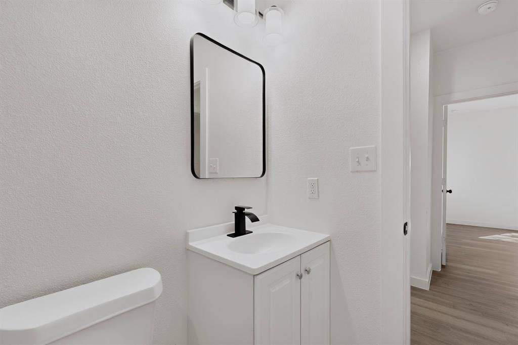651 Ezekial Avenue, Dallas, TX 75217 White vanity with two cabinet doors, integrated sink, and matte black faucet