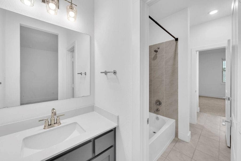 8300 Bethpage Drive, McKinney, TX 75070 Vanity with a rectangular undermount sink, brushed nickel faucet, and a wall-mounted mirror