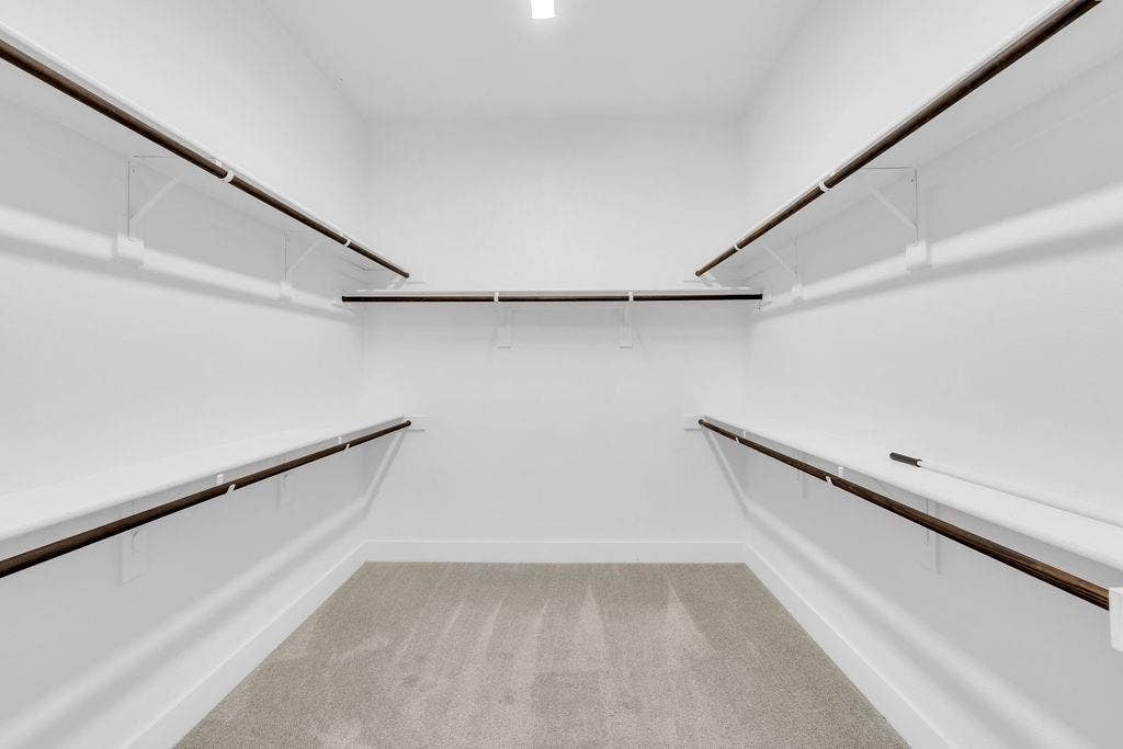 8300 Bethpage Drive, McKinney, TX 75070 Spacious walk-in closet with extensive shelving, multiple hanging rods, and light gray carpeting
