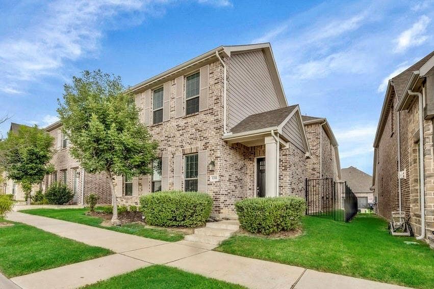 8300 Bethpage Drive, McKinney, TX 75070 Brick facade with shuttered windows, covered entryway, established shrubs, and a side fence