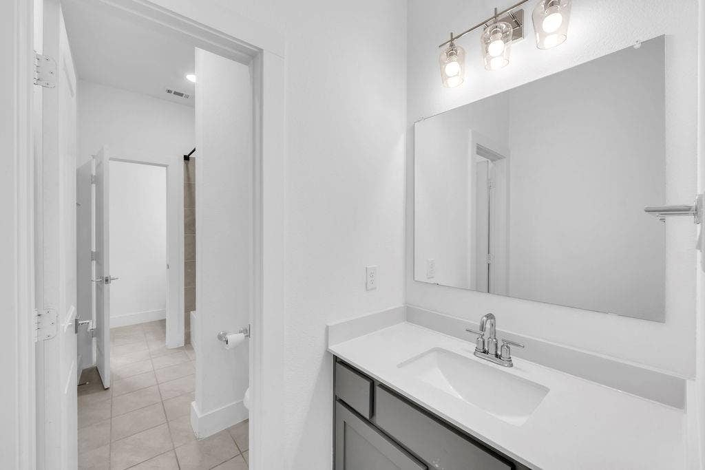 8300 Bethpage Drive, McKinney, TX 75070 Vanity with a polished chrome faucet, white countertop, and gray cabinetry