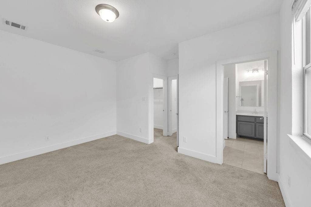 8300 Bethpage Drive, McKinney, TX 75070 Carpeted flooring, white walls, ceiling-mounted light fixture, window with white trim, and a bathroom with a vanity and mirror