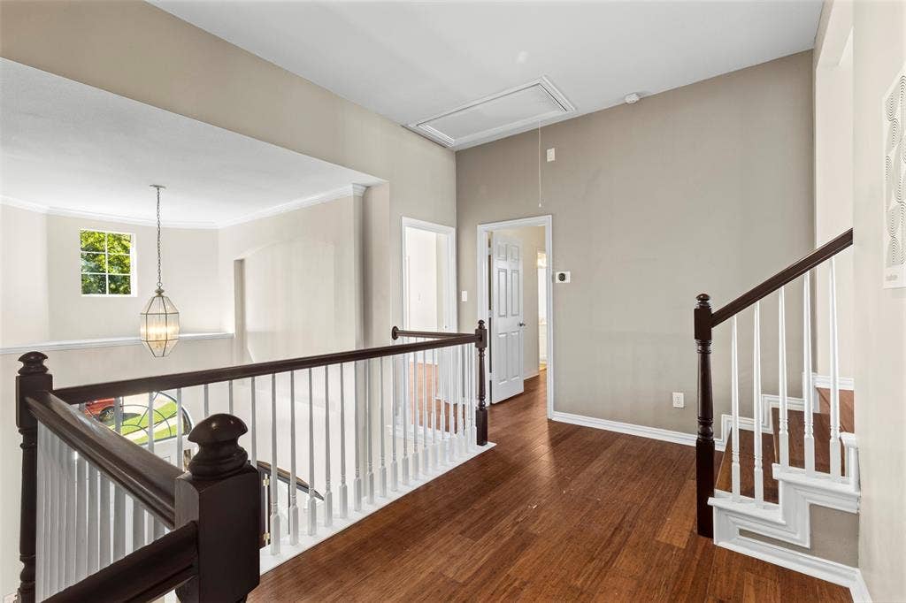 5401 Wolcott Place, Richardson, TX 75082 Hardwood flooring, painted walls, white trim, open railing, and a decorative pendant light fixture