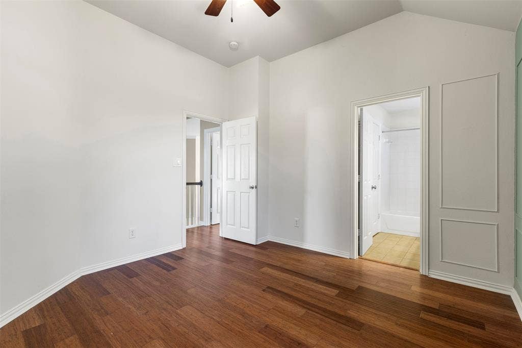 5401 Wolcott Place, Richardson, TX 75082 Vaulted ceiling with a wood-finish ceiling fan, wood-finish flooring, and white paneled interior doors