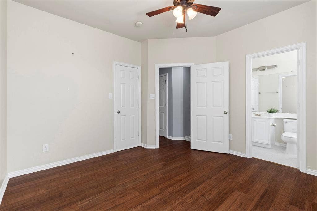 5401 Wolcott Place, Richardson, TX 75082 Wood-finish flooring, ceiling fan with integrated lighting, white interior doors, and a bathroom featuring a vanity with a white countertop and a toilet