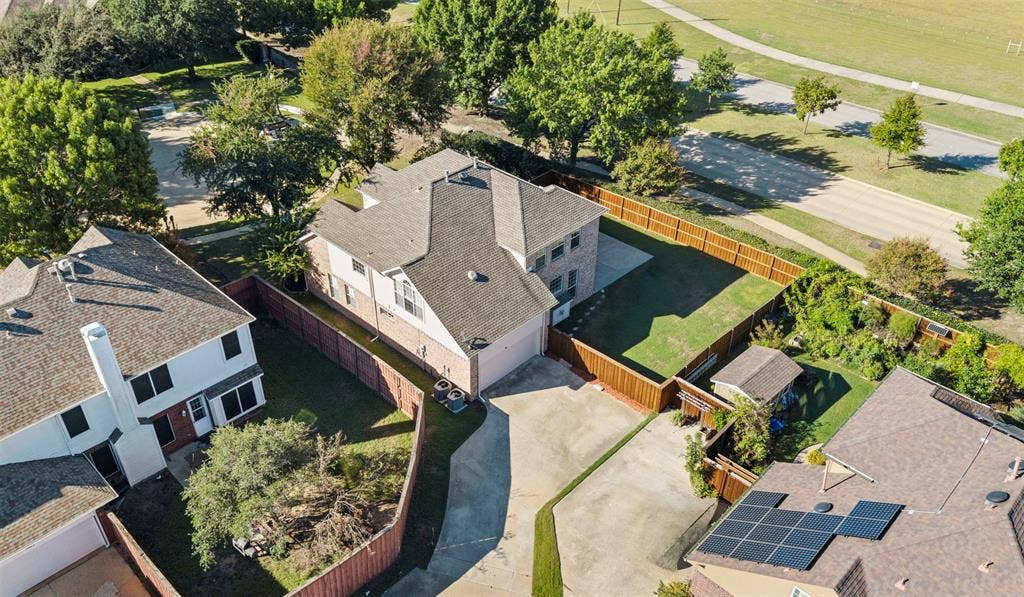 5401 Wolcott Place, Richardson, TX 75082 Two-story residence with a gabled roof, private fenced yard, and an attached two-car garage