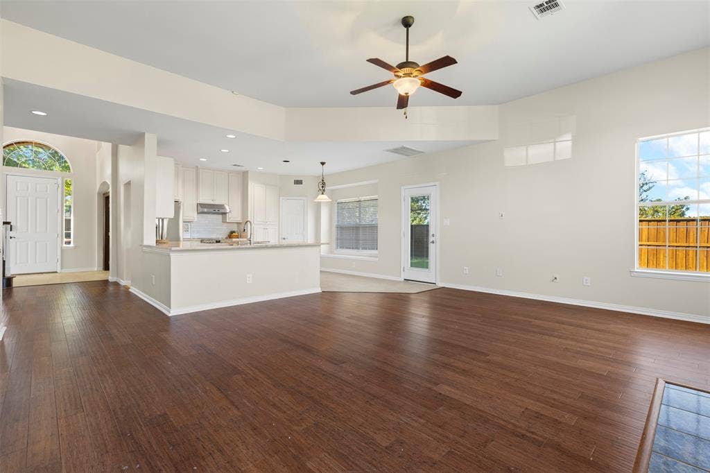 5401 Wolcott Place, Richardson, TX 75082 Expansive living area with wood-finish flooring, vaulted ceilings, and a ceiling fan