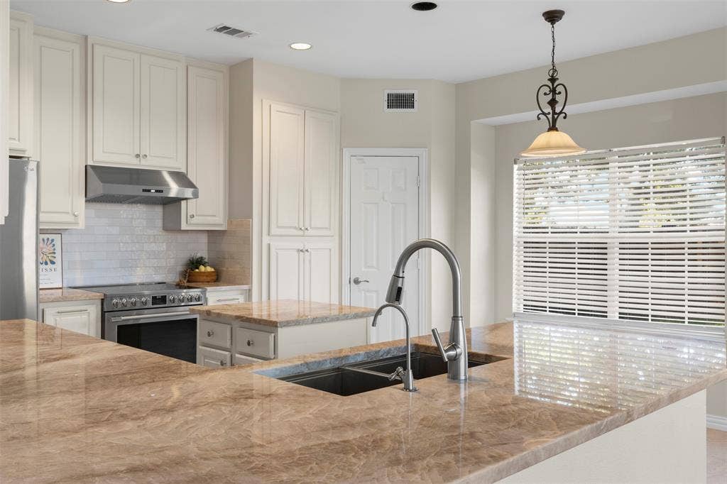5401 Wolcott Place, Richardson, TX 75082 Expansive countertops, stainless steel appliances, integrated sink, pendant lighting, and recessed lighting