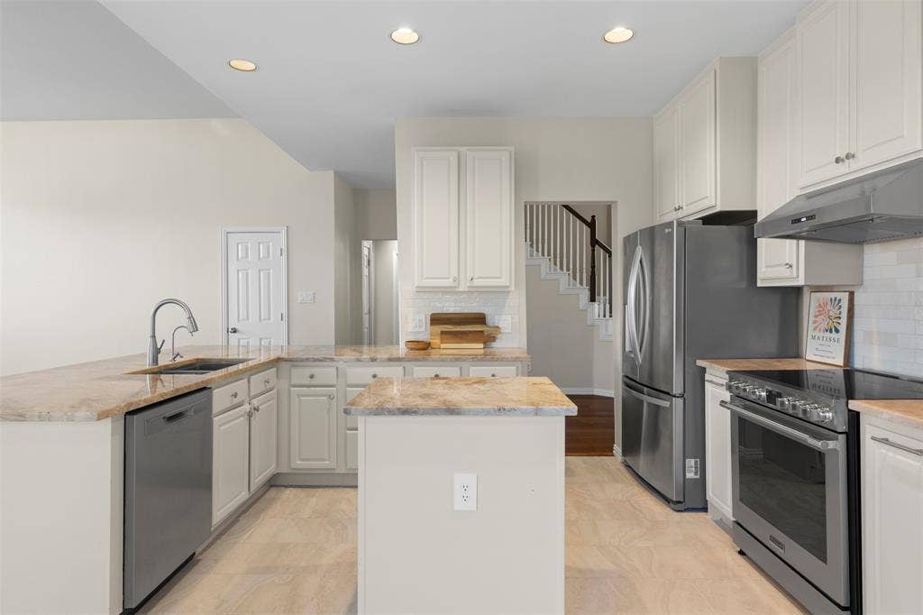 5401 Wolcott Place, Richardson, TX 75082 Kitchen featuring light-toned cabinetry, light-toned countertops, tile flooring, stainless steel appliances, and recessed lighting