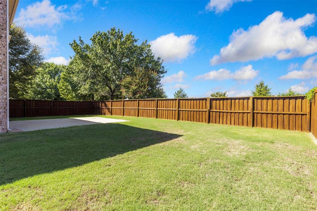 5401 Wolcott Place, Richardson, TX 75082 Expansive backyard featuring a lush lawn, a sizable concrete patio, and a full privacy fence