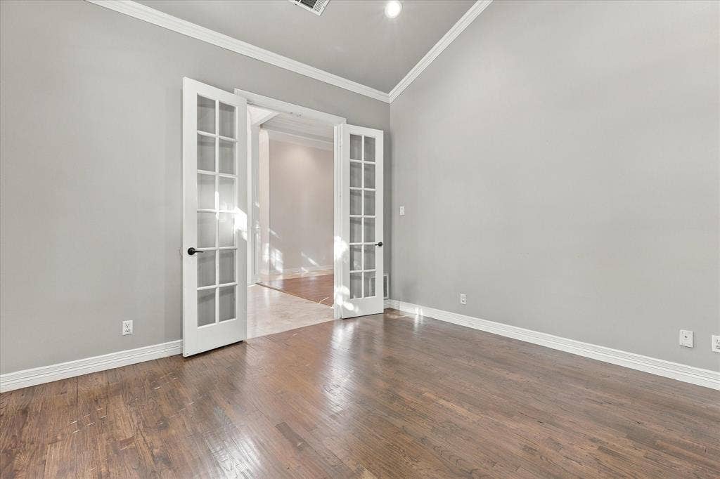 Wood-finish flooring, white trim, and light gray wall paint