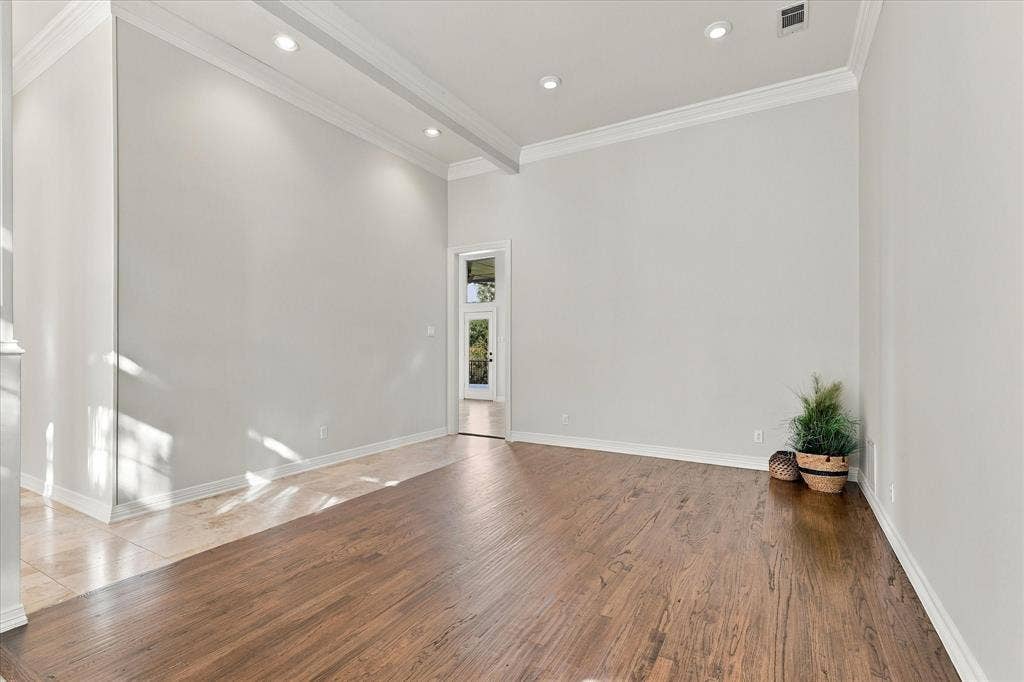 Hardwood flooring, recessed lighting, crown molding, and a paneled entry door with transom window