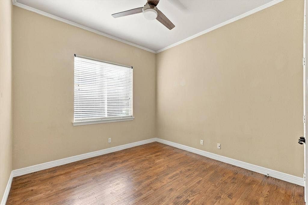 Wood-finish flooring, ceiling fan, window with blinds, and crown molding