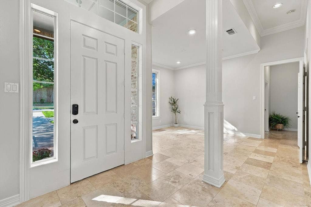 Entryway with a paneled door, transom window, and sidelights