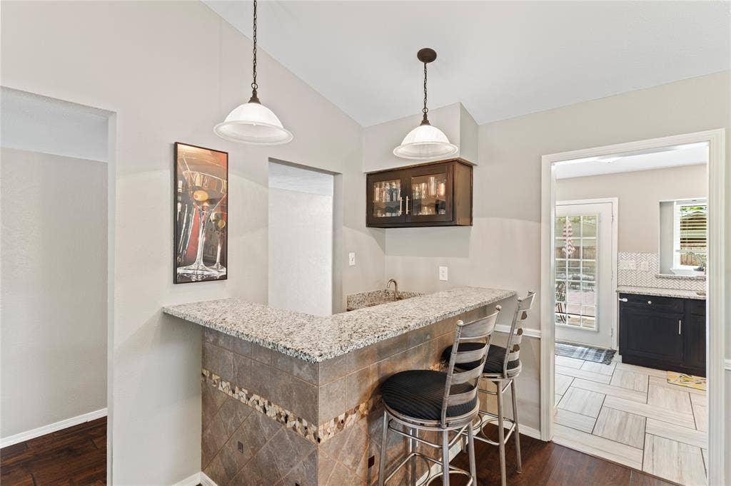 Built-in bar with granit ecountertop, tiled base, and integrated sink.