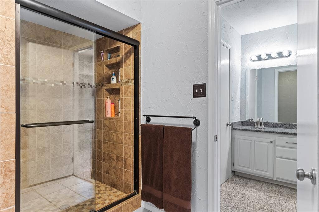 Glass-enclosed shower with tiled walls and built-in niches