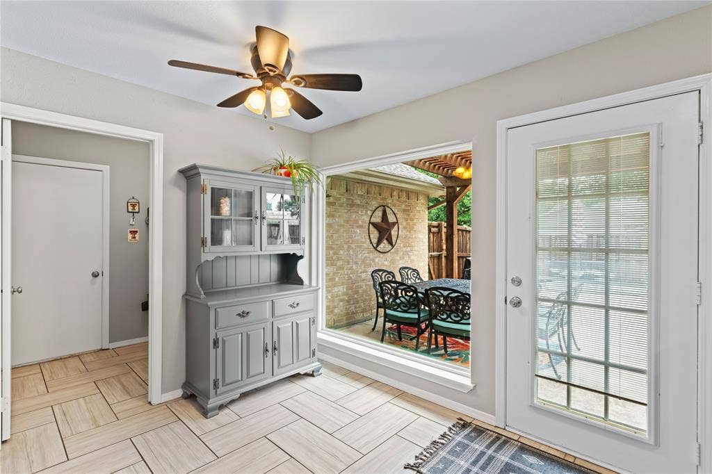 Herringbone pattern tile flooring, a ceiling fan with integrated lighting, and a large picture window