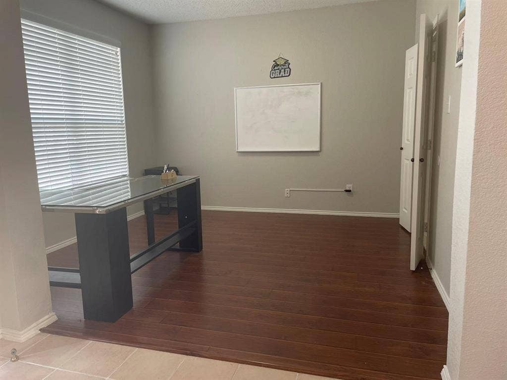Room featuring wood-finish flooring, neutral wall paint, and horizontal window blinds
