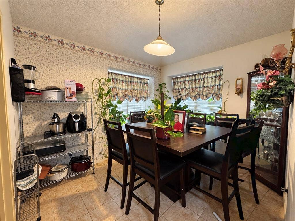 725 Andalusia Trail, DeSoto, TX 75115 Dining space featuring a wood-finish table, recessed windows, tile flooring, and a ceiling-mounted light fixture