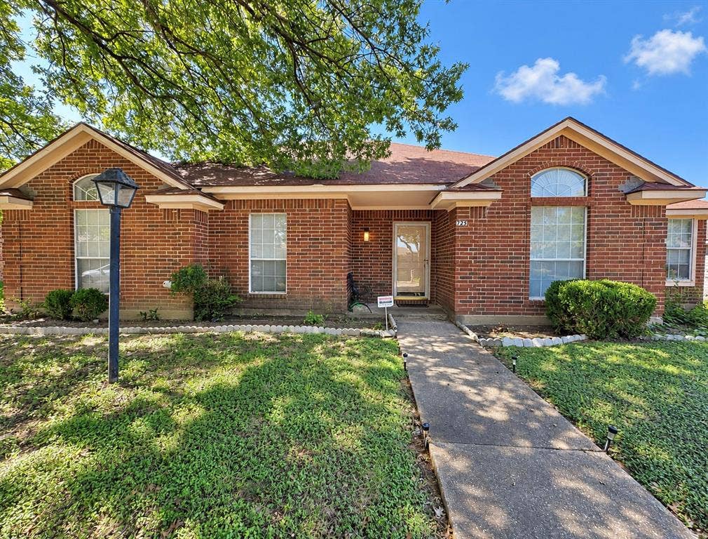 725 Andalusia Trail, DeSoto, TX 75115 Brick exterior residence featuring a front entry, arched window, and mature landscaping