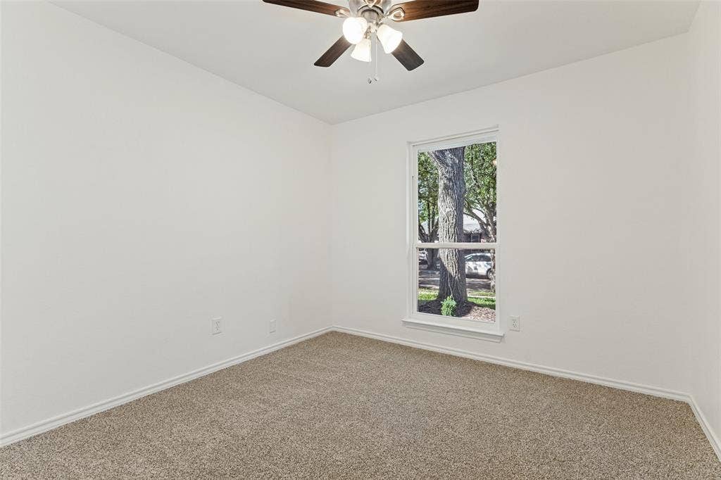 7440 Bear Lake Drive, Fort Worth, TX 76137 Neutral carpeted flooring with white wall finishes, a single-pane window, and an installed ceiling fan