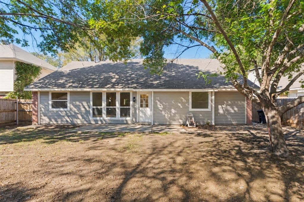 7440 Bear Lake Drive, Fort Worth, TX 76137 Rear exterior with wood fencing, a patio, and a shingled roof