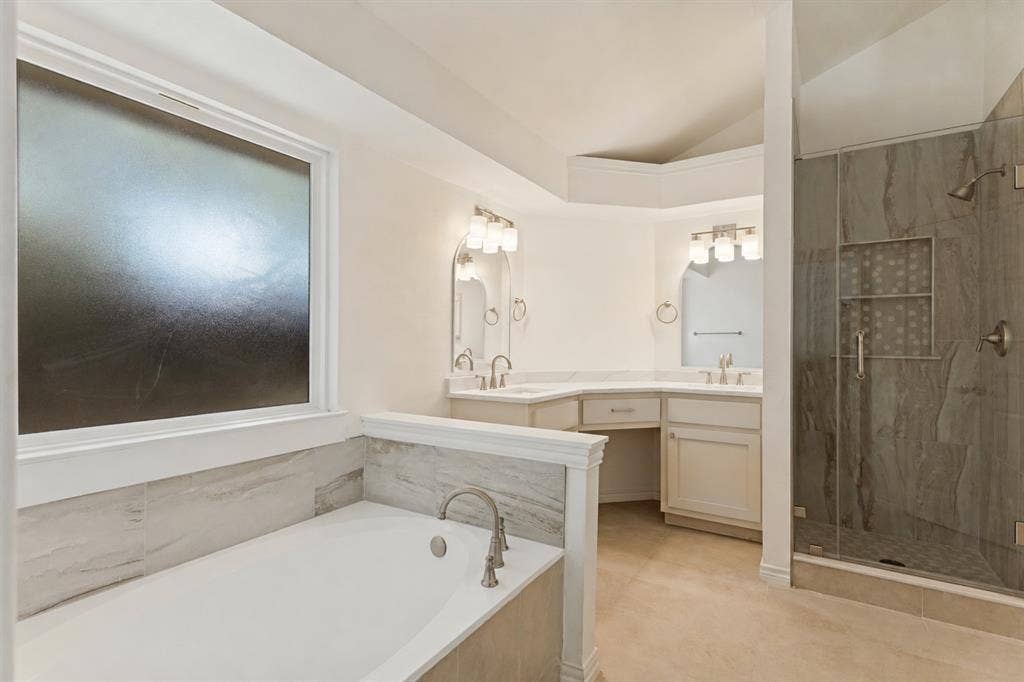 7440 Bear Lake Drive, Fort Worth, TX 76137 Recessed soaking tub, expansive dual vanity, separate glass-enclosed shower, tile flooring, and vaulted ceiling