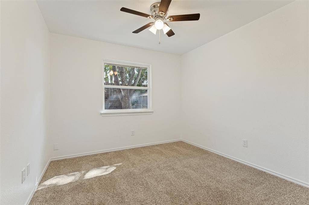 7440 Bear Lake Drive, Fort Worth, TX 76137 Neutral wall palette with a ceiling fan light fixture, window, and carpeted flooring