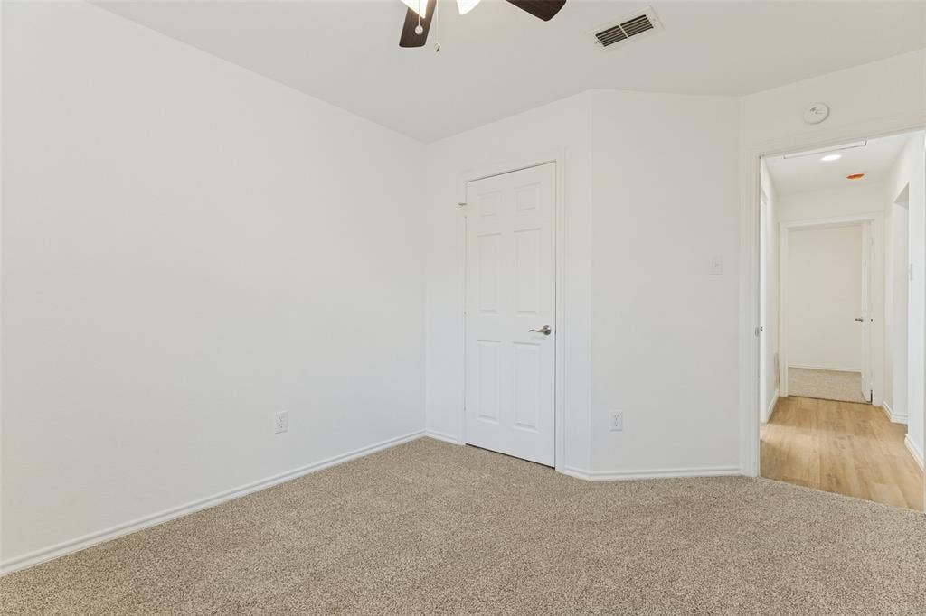 7440 Bear Lake Drive, Fort Worth, TX 76137 Neutral wall finishes, carpet flooring, a ceiling fan with integrated lighting, and a paneled door with a lever handle