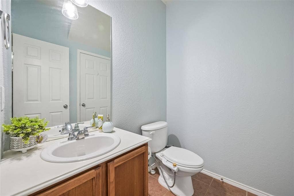 2209 Stonepark Place, McKinney, TX 75071 Bathroom featuring a vanity with an integrated sink, chrome-finish faucet, and a large wall-mounted mirror