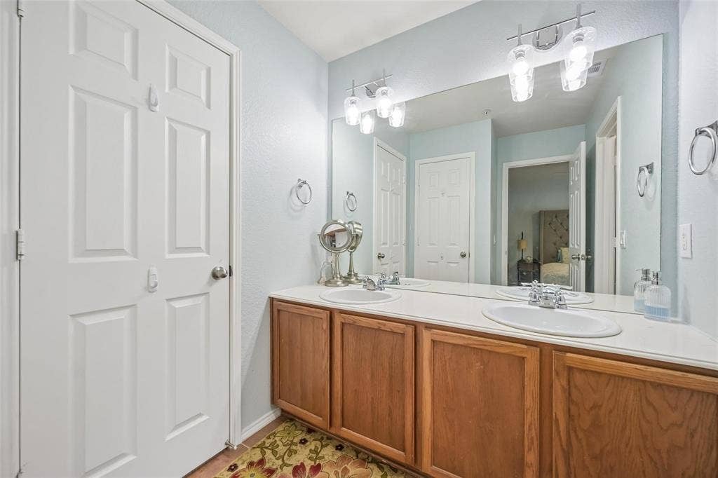 2209 Stonepark Place, McKinney, TX 75071 Double vanity with wood-finish cabinetry and integrated sinks