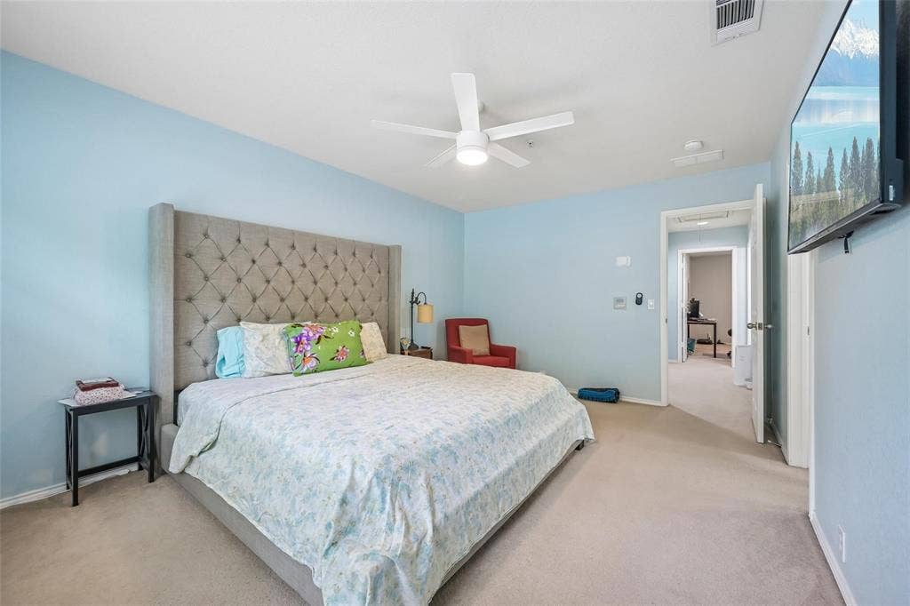 2209 Stonepark Place, McKinney, TX 75071 Carpeted bedroom featuring a ceiling fan with integrated lighting and a doorway leading to an additional interior room