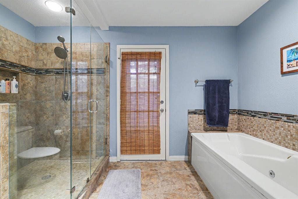26 Brookhaven Drive, Lucas, TX 75002 Glass-enclosed shower with multiple showerheads, recessed lighting, and a built-in shelf